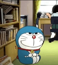 doraemon is sitting on the floor in a room with a bookshelf and a desk .