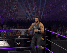 a wrestler in a goat tank top stands in a ring