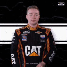 a race car driver wearing a cat shirt waves his hand