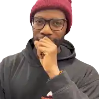a man wearing glasses and a red beanie has his hand to his mouth