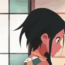 a close up of a girl 's face and back with a window in the background .