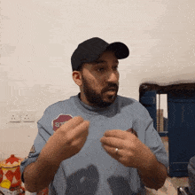 a man wearing a black hat and a blue shirt that says stop