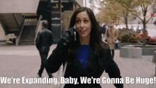 a woman talking on a cell phone with the words we 're expanding baby we 're gonna be huge behind her