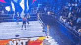 two wrestlers in a ring with nxt written on the side