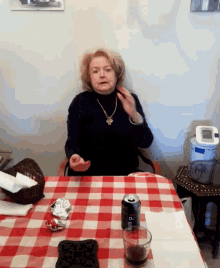 a woman is sitting at a table with a can of dr pepper