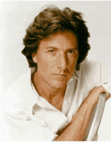 a man in a white shirt has his arm resting on a metal bar