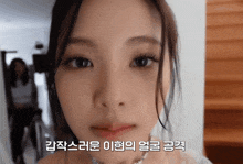 a close up of a woman 's face with korean writing on the bottom right
