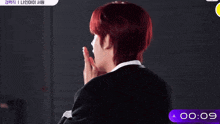 a young man with red hair is standing in front of a timer with the time of 0:07