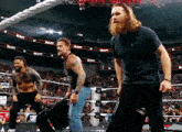 a group of men are standing in a wrestling ring with the word raw on the wall behind them