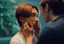a man and woman touching each other 's faces with their hands