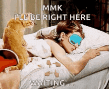 a cat is sitting on the floor next to a woman sleeping in a bed ..