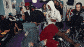 a group of people are gathered in a room and one of them has a delta hoodie on