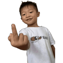 a young boy wearing a white shirt that says bab love you gives the middle finger