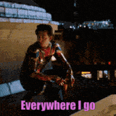 a man in a spiderman suit is squatting down with the words " everywhere i go " behind him