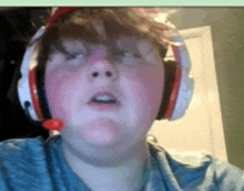 a young boy wearing headphones and a microphone on his face .
