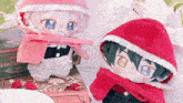 two stuffed dolls wearing red hoods are sitting next to each other on a table ..