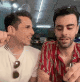 a couple of men are sitting next to each other in a restaurant .