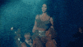 a woman is dancing on a stage in front of a crowd of people in a dark room .