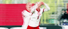 two soccer players are celebrating a goal with their hands in the air