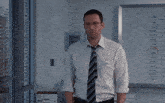 a man in a white shirt and tie stands in front of a white board that says 1:00 on it