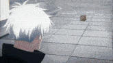 a man with white hair looks at a cube on the floor