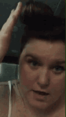 a close up of a woman 's face with a thumbs up
