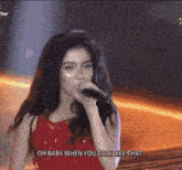 a woman in a red dress singing into a microphone with the words oh baby when you talk like that above her