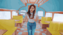 a woman in a white top and blue jeans is standing in a diner with her hands outstretched .