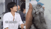a man in a white shirt is sitting next to a kitten with chinese writing on it
