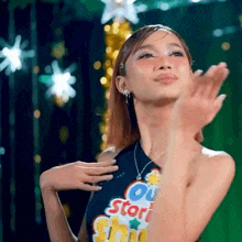 a woman in a halter top is clapping her hands in the air .