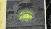 a picture of a pumpkin with a green light coming out of it 's mouth .