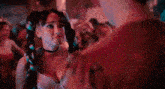 a man and woman are dancing together in a crowded room .