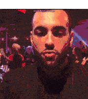 a man with a beard wearing a striped suit is standing in front of a crowd of people .