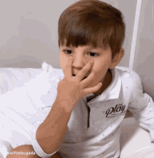 a little boy wearing a white shirt that says play on it