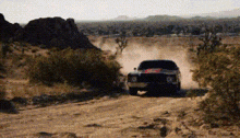 a truck is driving down a dirt road .