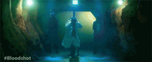 a man in a lab coat is standing in a dark room taking a picture with his camera .