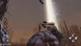 a man in a plaid shirt is kneeling down in front of a light beam .