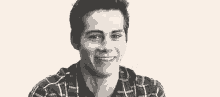 a young man in a plaid shirt is sticking his tongue out .