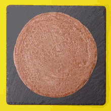 a brown circle on a black slate tray