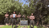 a group of men standing in front of a sign that says " come home scara "