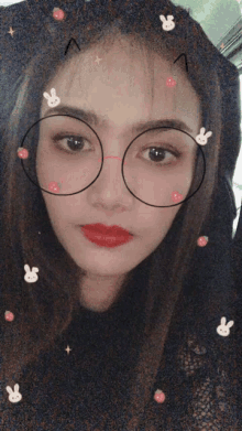 a woman wearing glasses and a cat hat with rabbits on it