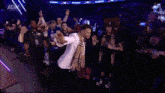 a man in a white suit is walking in front of a sign that says aew on it