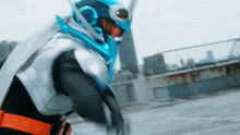 a man in a blue and white superhero costume stands on a rooftop