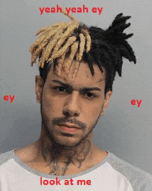 a man with dreadlocks and a beard is wearing a white shirt and says yeah yeah ey look at me .