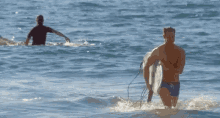 a man carrying a surfboard is walking out of the water