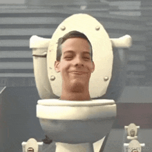 a young man is sitting on a toilet with his head sticking out of it .