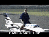 a man is riding a small airplane on a runway with the words have a safe trip below him .