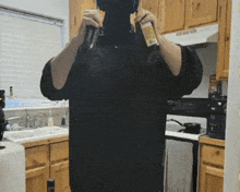 a man in a black shirt is taking a picture of himself