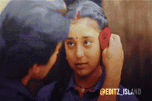 a man putting a flower in a woman 's ear with the hashtag editz island
