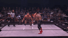 two men are wrestling in a ring with a aew logo on the wall behind them